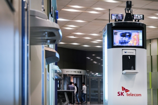 코로나19 방역로봇이 UV램프를 이용해 ATM기를 방역하고 있는 모습 (사진제공=SK텔레콤)