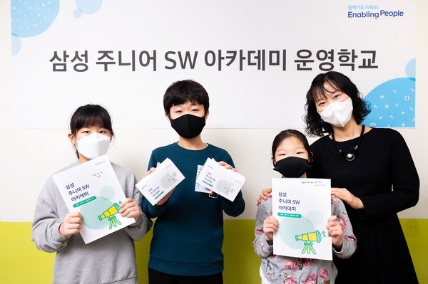 '삼성 주니어 SW 아카데미'를 운영하는 충청북도 괴산 명덕초등학교에서 담당 교사와 학생들이 AI 수업 교재를 보여주고 있다. (사진=삼성전자)