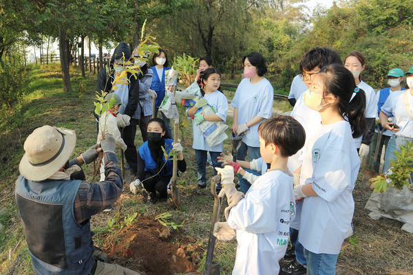 효성 임직원과 서울 시민분들이 마포구 노을공원에 위치한 효성 나눔의 숲에서 나무 심기 행사에 참여하고 있다. [사진=효성 제공]