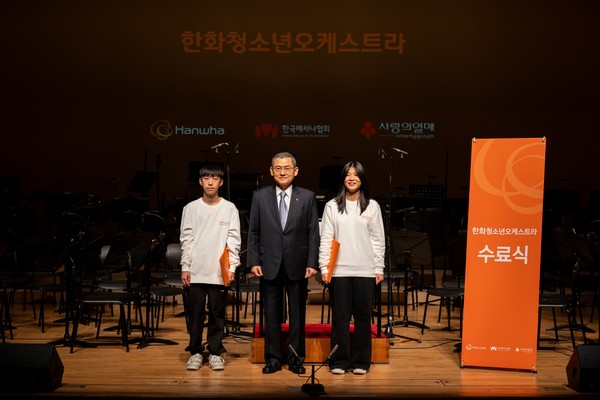 김신연 단장이 천안과 청주 앙상블의 대표 단원에게 수료증을 전달하고 기념촬영을 하고 있다.[사진=한화그룹 제공]